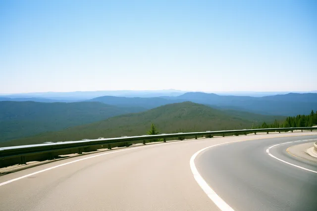 Blue Ridge Parkway asphalt road curving through blue Appalachian mountain ridges near Asheville. What does driving the Blue Ridge Parkway from Asheville cost?